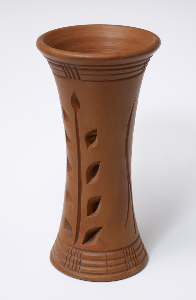 Tall terracotta vase with leaf shaped pierced motifs